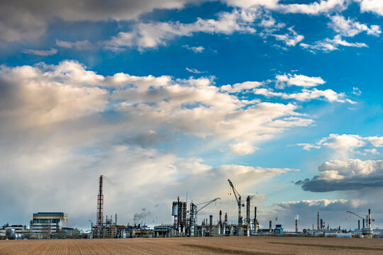 Slowly Floating Clouds Over A Large Oil Refinery. Cloud Movement. Smoke Comes Out Of The Pipes Above The Chemical Industry Plant. Environmental Pollution