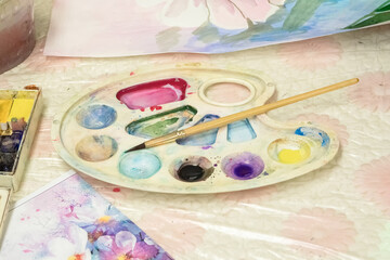 Brush and watercolor palette on the dirt table. Paints and brushes for drawing.