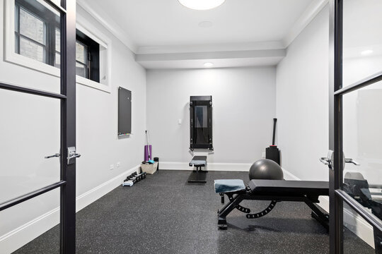 Simple Home Gym. Small Room In Basement With Workout Equipment.