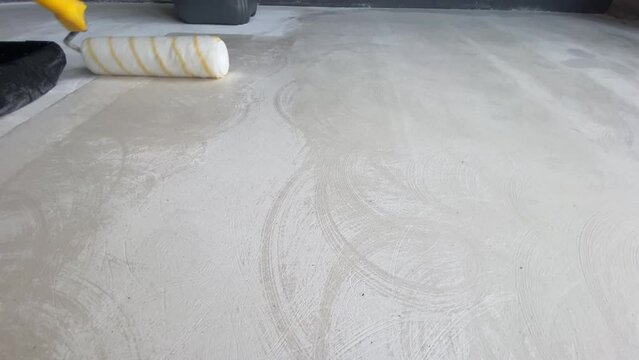 The process of priming the floor with a roller