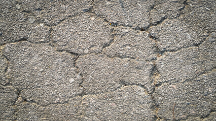 Crack on the asphaltic surface. Natural pattern on textured surface. Ruined of the walkway.