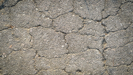 Crack on the asphaltic surface. Natural pattern on textured surface. Ruined of the walkway.