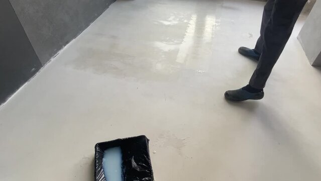 The process of priming the floor with a roller