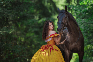 A young woman in a vintage yellow dress walks with a brown horse in a green park on a summer day