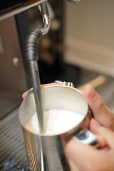 Barista is froth the milk at moody coffee shop