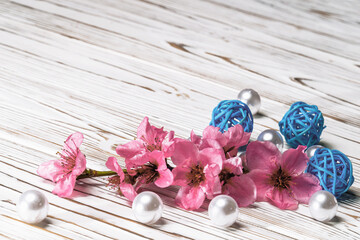 Sakura branch and mother-of-pearl on a white wooden background.