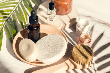 Fototapeta na wymiar set of skin care and wellness products - serum bottle, exfoliation brush and soap, cream and sponge