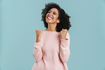 Black young woman laughing while making winner gesture