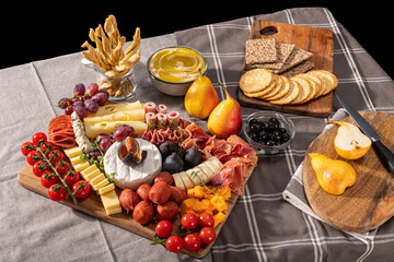 Cured cheese and meze platter rich in variety of fruits, cheese, meat and crackers