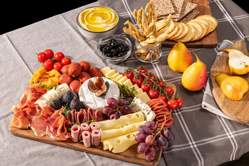 Cured cheese and meze platter rich in variety of fruits, cheese, meat and crackers