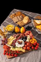 Cured cheese and meze platter rich in variety of fruits, cheese, meat and crackers
