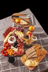 Obraz na płótnie Canvas Cured cheese and meze platter rich in variety of fruits, cheese, meat and crackers