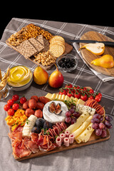Cured cheese and meze platter rich in variety of fruits, cheese, meat and crackers