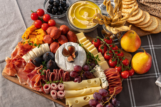 Cured cheese and meze platter rich in variety of fruits, cheese, meat and crackers