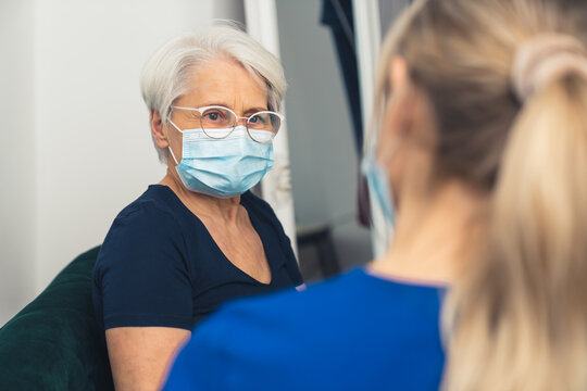 Senior Woman Visited By Home Care Specialist During Pandemic Medium Closeup Living Room Healthcare Concept . High Quality Photo