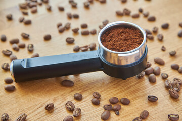 Coffee maker horn with Ground coffee on wooden background and coffee beans