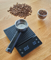 Coffee maker horn lies on coffee scales, on the background of wooden countertops, coffee beans