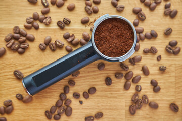Coffee maker horn with Ground coffee on wooden background and coffee beans