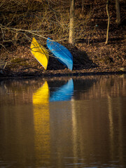 yellow and blue canoes on the shore