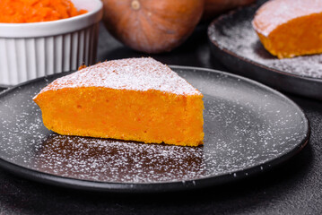Pumpkin pie, tart made for Thanksgiving day with whipped cream on a black plate