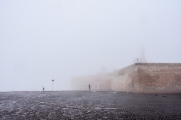 old palace and man vaguely seems behind fog