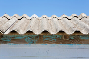 Old aged dangerous roof made of corrugated asbestos panels - one of the most dangerous materials in...