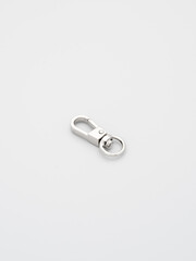 The heap of metal lobster claw clasp for making bags and backpacks lying on a gray background. Chrome-plated metal accessories and supplies for bags, backpacks. Handbags making, copy space