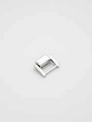 Metal adjusters and frames for making bags and backpacks on a grey background. Chrome-plated metal frames for handbags straps. Sewing accessories, bags making