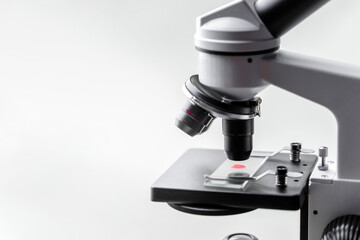 Cocept blood investigation. Microscope with a bright red drop on the slide