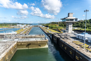 Panama Canal: Agua Clara Locks, set of three new locks with Atlantic Bridge. Agua Clara control tower (torre de control). Rolling gate half opened half closed.  - obrazy, fototapety, plakaty