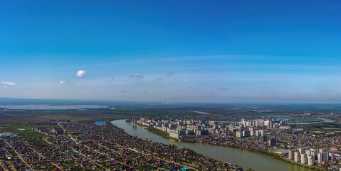 aerial panorama of the bend of the Kuban River near the western outskirts of the city of Krasnodar. Shapsug reservoir on the horizon in front of the Caucasus mountains