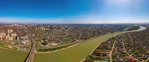 Panoramic aerial view of the southwestern part of Krasnodar city center and the Kuban river on a spring sunny day. - obrazy, fototapety, plakaty