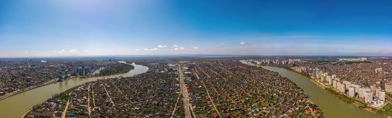 large aerial view of the southwestern part of the city center of Krasnodar, the village of Novaya Adygea and the Kuban river near the Turgenev bridge on a spring sunny day.