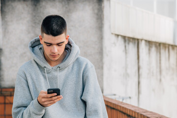 urban trendy millennial young man with mobile phone