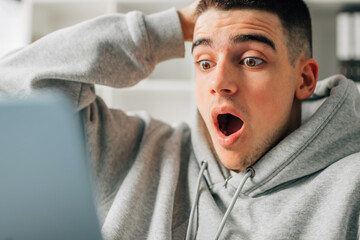 astonished young man looking at the computer