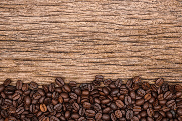 Fototapeta premium coffee beans on wood background space for sample text. top view. Agriculture, coffee shop concept.