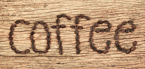 words coffee made of coffee beans on the old wooden floor. top view. Agriculture, coffee shop concept.                       
