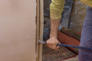A man removes an old doorframe on a wooden interior door the replacement renovation services apartment