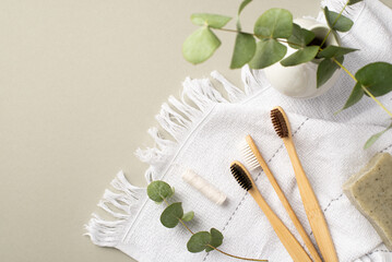 No plastic concept. Top view photo of bamboo toothbrushes dental floss soap white towel and vase...