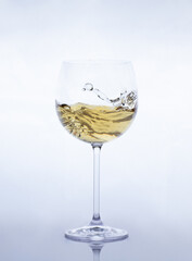  white wine glasses with moving liquid on a greyish-white background