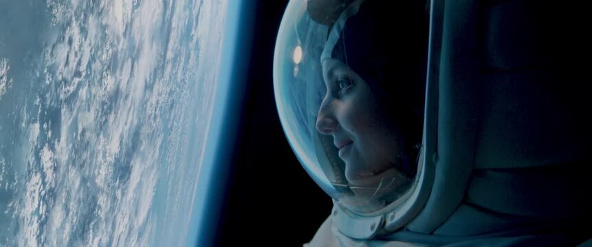 Portrait of Caucasian female astronaut during spacewalk on the Earth orbit. Space exploration, Mars mission. Shot with 2x anamorphic lens