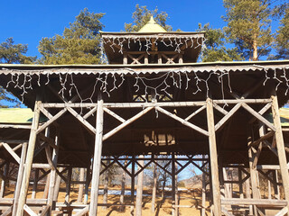 Wooden gazebo in the city of Cavalese against the blue sky on a sunny day.