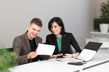 Businessman and businesswoman meeting in modern office working on laptop, business meeting