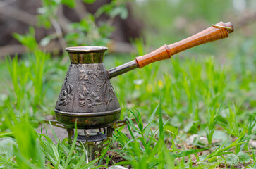 Turkish coffee on vacation in nature. Copper metal coffee maker on a tourist gas burner. Delicious...
