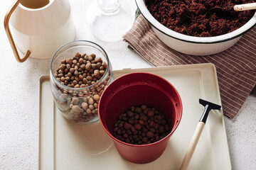 Flower pot with drainage pebbles on a white concrete background