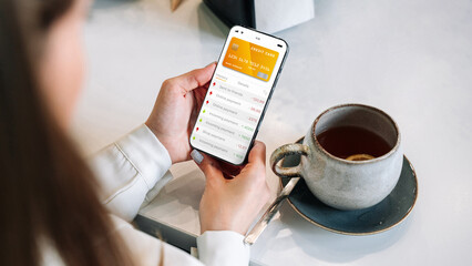Internet based banking. Girl holding mobile phone with internet online bank app. Credit card wallet...
