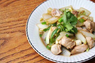 Stir-fried pork with chilli with onions and spring onions served in a white plate, Stir-fried pork with chilli is a popular Thai dish that Thai people eat.