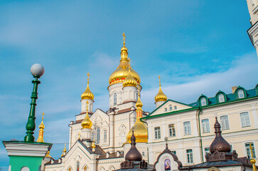 Fototapeta na wymiar Orthodox Christian cathedral with golden domes. Side view. Religious buildings. Holy Dormition Pochaiv Lavra in Ukraine.