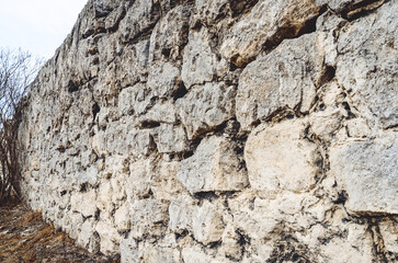 Stone wall. Paved wall with a rough, clear texture and deep lines between large stones.