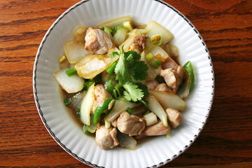 Stir-fried pork with chilli with onions and spring onions served in a white plate, Stir-fried pork with chilli is a popular Thai dish that Thai people eat.